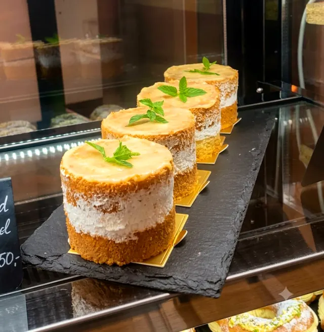 Naked-Cake-Törtchen mit Minze auf einer Schieferplatte in der Vitrine